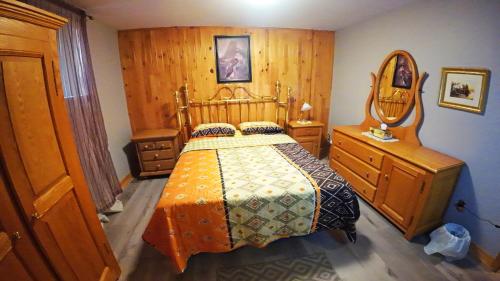 a bedroom with a bed and a dresser and a mirror at Cottage with inground pool outside in Saint-Damien