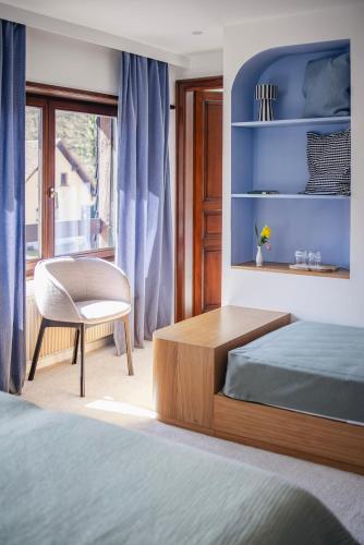 a bedroom with a bed and a desk and a chair at Hotel Au Vieux Moulin in Graufthal