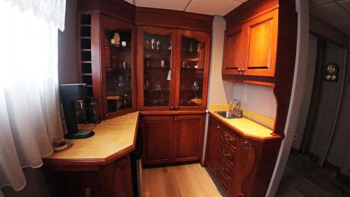 a small kitchen with wooden cabinets and a sink at Cottage with inground pool outside in Saint-Damien