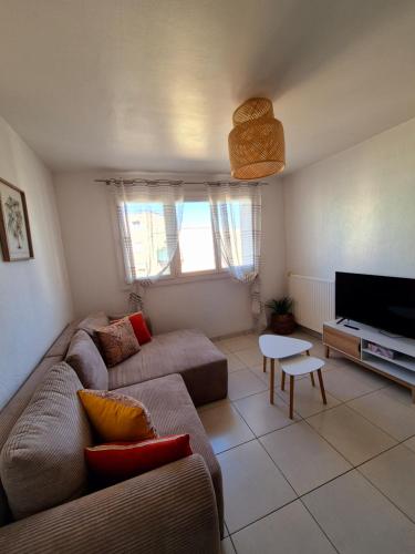 un salon avec un canapé et une télévision dans l'établissement Le Chap'Appart, T3, à Narbonne