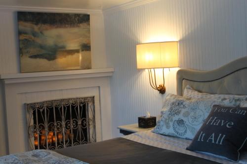 a bedroom with a bed with a fireplace and a lamp at Dungeness Barn House Bed and Breakfast at Two Crows Farm in Sequim