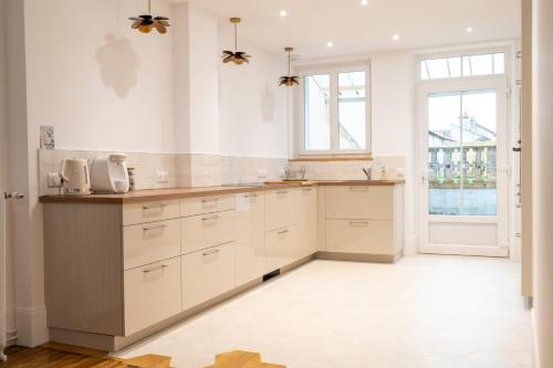 une cuisine avec des placards blancs et une grande fenêtre dans l'établissement L'étape Pinot Meunier, à Dormans