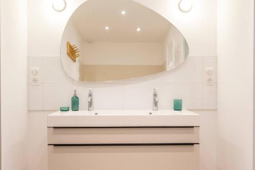 a bathroom with a sink and a mirror at L'étape Pinot Meunier in Dormans