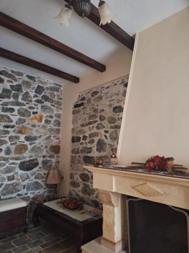 a stone fireplace in a living room with a stone wall at Traditional house in Kampia in Kambiá