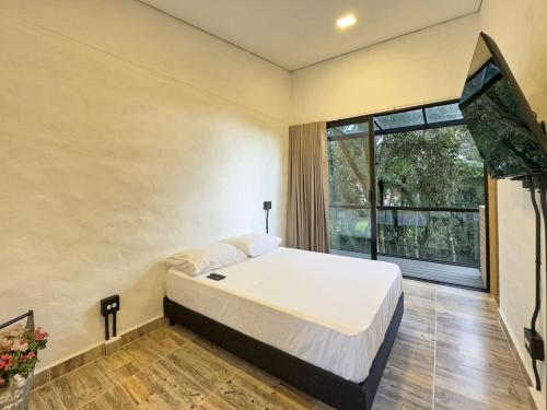 Un dormitorio con una cama y una ventana grande. en 3br Esmeralda Country Home Santa Elena, en Santa Elena