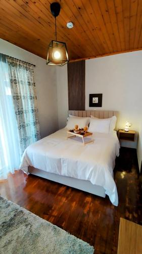 a bedroom with a large white bed with a wooden ceiling at ROSE house in Nydri