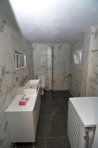 a bathroom with a toilet and a sink and a shower at IRON House in Kavála