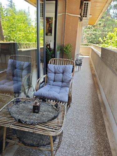 two wicker chairs and a table on a porch at Central Apartment with Garden in Skopje