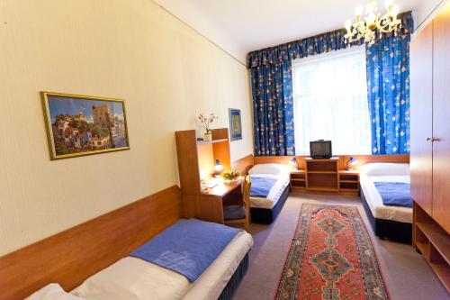 a hotel room with three beds and a window at Hotel-Pension Bleckmann in Vienna