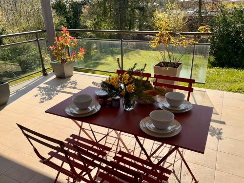 une table avec des tasses et des soucoupes sur une terrasse dans l'établissement Spacieux appartement de deux chambres, à Mulhouse