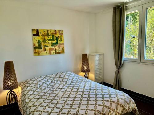 une chambre avec un lit et deux lampes et une fenêtre dans l'établissement Spacieux appartement de deux chambres, à Mulhouse