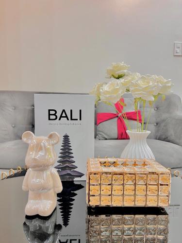 a table topped with a box and a vase at HPT Home II Vinhome Marina chuỗi Apartment - Homestay in Hai Phong
