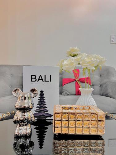 a living room with a table with a vase and a couch at HPT Home II Vinhome Marina chuỗi Apartment - Homestay in Hai Phong