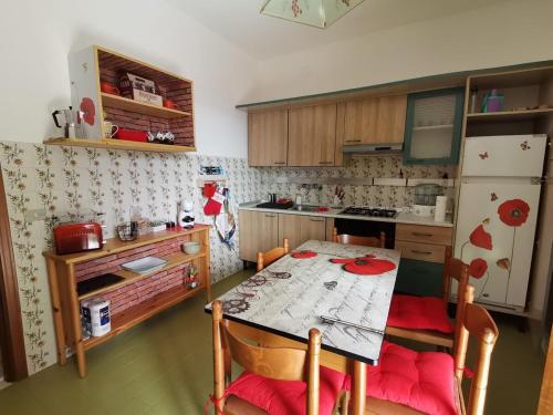 a small kitchen with a table and a refrigerator at Sunny House -Charming apartment in the nature in Casone