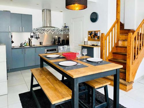 une cuisine avec une table en bois dans une cuisine avec des armoires bleues dans l'établissement Résidence B20-perros Guirec - Maison avec terrasse près du port de Perros-Guirec MAE-3764, à Perros-Guirec