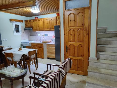 a kitchen with a table and chairs and a door at Agiasos House in Agiásos