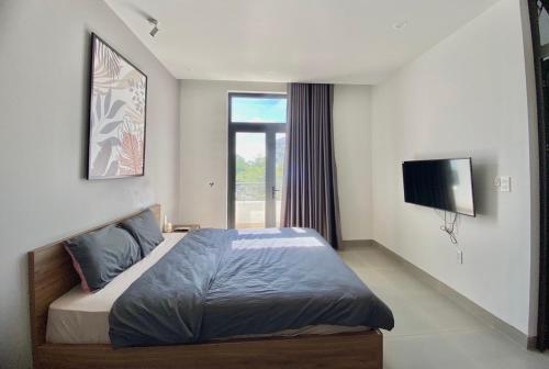 a bedroom with a bed with a television and a window at HPT Home II Vinhome Marina chuỗi Apartment - Homestay in Hai Phong