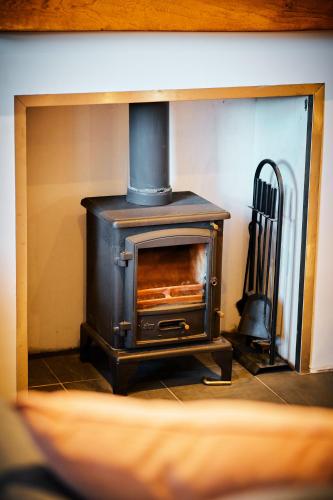 a woodburning stove in a room with a practition at Blairgowrie - Cosy terraced cottage sleeps 4 in Blairgowrie