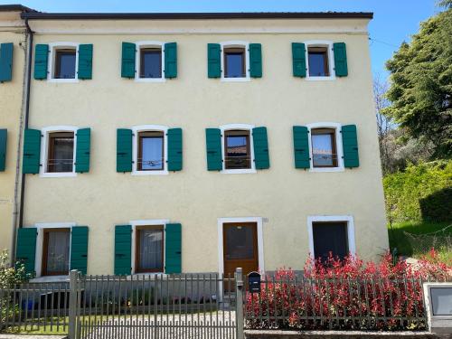 a house with green shutters and a fence at Villa Hermes in Costermano