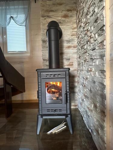a stove in a room with a brick wall at Uroczy domek nad Gilem in Miłomłyn