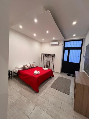 Un dormitorio con una cama con una manta roja. en La casa di Giorgia, en Catania