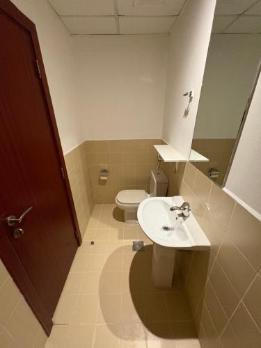 un bagno con un water, un lavandino e uno specchio di Horizon Rooms JBR a Dubai