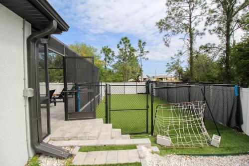 a fence with a soccer goal in a yard at Chic 3 BR Private Pool Home in Lehigh Acres in Lehigh Acres