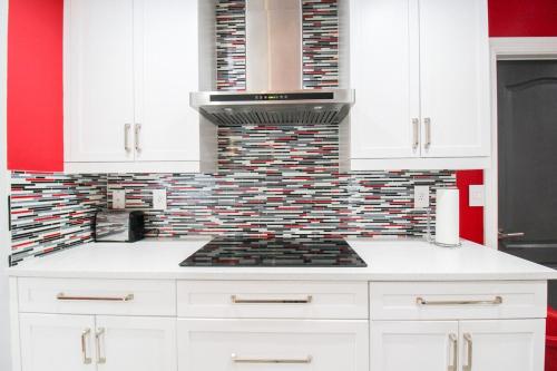a kitchen with white cabinets and a stove top oven at Chic 3 BR Private Pool Home in Lehigh Acres in Lehigh Acres