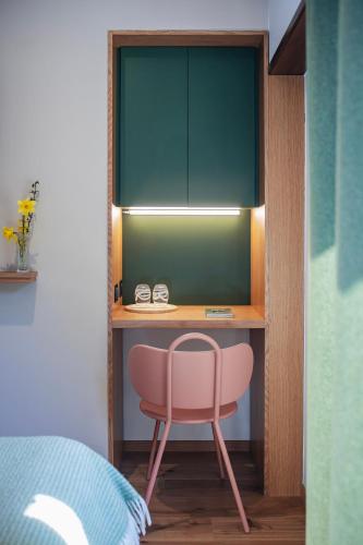 a desk with a pink chair in a bedroom at Hotel Au Vieux Moulin in Graufthal