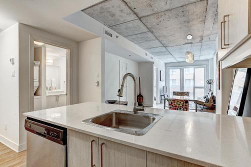 een keuken met een roestvrijstalen wastafel in een kamer bij Le CINQ in Montreal