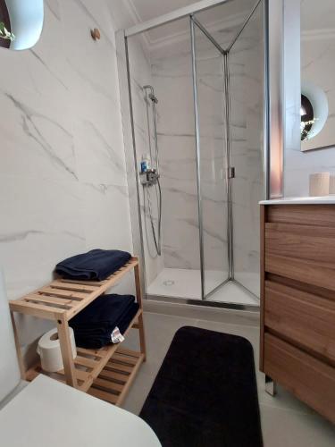 a bathroom with a shower and a wooden shelf with towels at Vida Boa in El Dueso