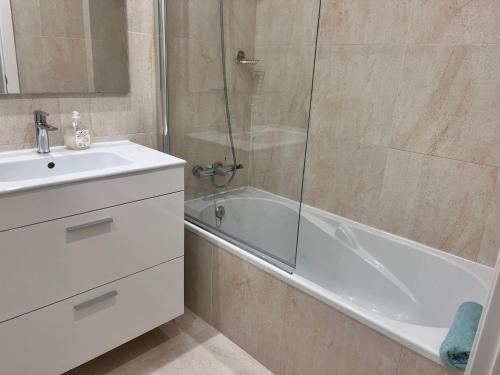 a bathroom with a shower and a tub and a sink at Vilamar - Ribamar in Ribamar
