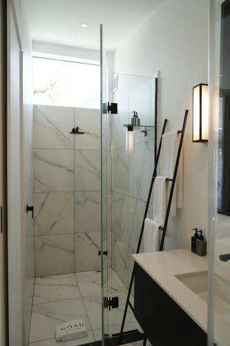 a glass shower in a bathroom with a sink at âmé by NOAH in Cape Town