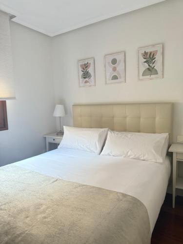 a bedroom with a large bed with white sheets and pillows at MIRADOR DEL CIELO "Parking incluido" in Ávila