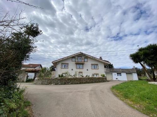 a large white house on a road at Villa Buganvilla in Arnuero