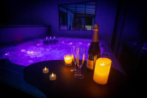 - une bouteille de vin et des bougies sur une table dans une pièce sombre dans l'établissement L'étincelle, à Saint-Christol-lès-Alès