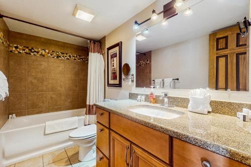 a bathroom with a sink and a tub and a toilet at Mountain Dreams Condo in Fraser