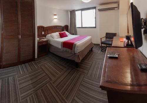 a hotel room with a bed and a desk at Ramada Plaza by Wyndham Leon in León
