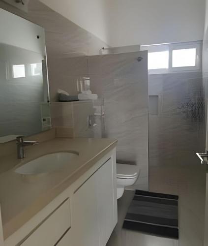a bathroom with a sink and a toilet and a mirror at Departamento Hanna #2 Bucerias in Bucerías