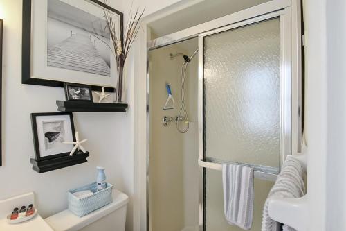 Un baño con ducha con puerta de cristal. en 2 BR second story condo close to beaches, en Venice