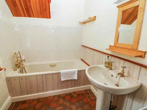 a bathroom with a tub and a sink and a bath tub at Slade Cottage in Ashbourne