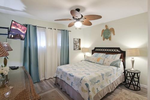 Un dormitorio con una cama y un ventilador de techo. en 2 BR second story condo close to beaches, en Venice