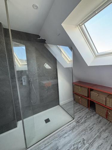 La salle de bains mansardée est pourvue d'une douche et d'une lucarne. dans l'établissement Ty Ana Gwen, à Trébeurden