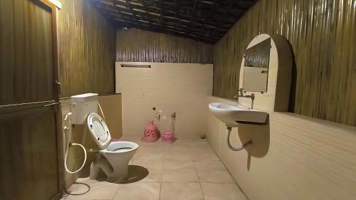 a bathroom with a toilet and a sink at Brook Ville in Sasan Gir