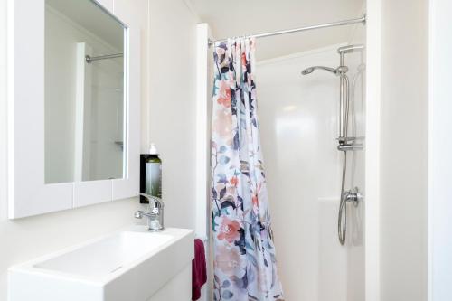 a bathroom with a sink and a shower at Riverside Whakatane Holiday Park in Whakatane