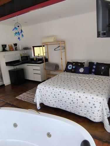 a bedroom with a bed and a bath tub at Chalés Recanto dos Sonhos in Camanducaia