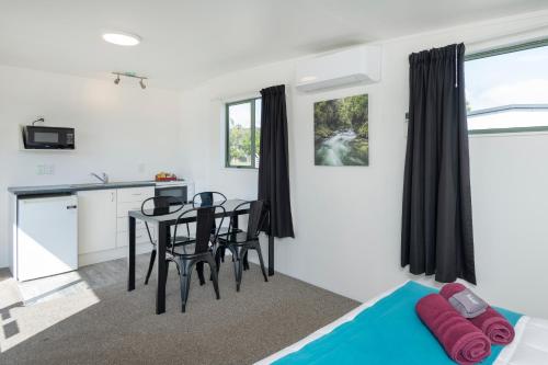 a room with a kitchen and a table and chairs at Riverside Whakatane Holiday Park in Whakatane