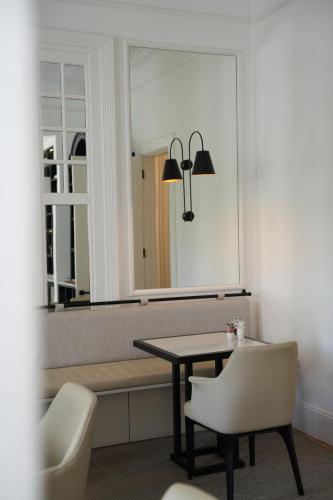 a dining room with a table and a mirror at âmé by NOAH in Cape Town