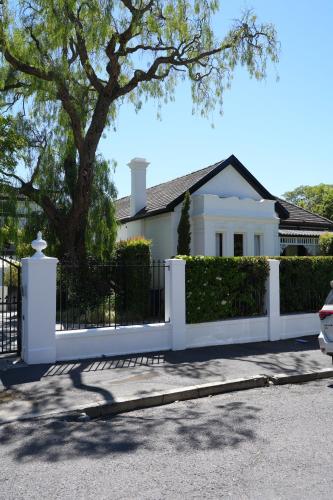 a white fence in front of a white house at âmé by NOAH in Cape Town
