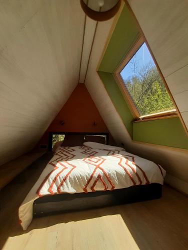 un lit dans une petite pièce avec une fenêtre dans l'établissement La cabanA, à Seix